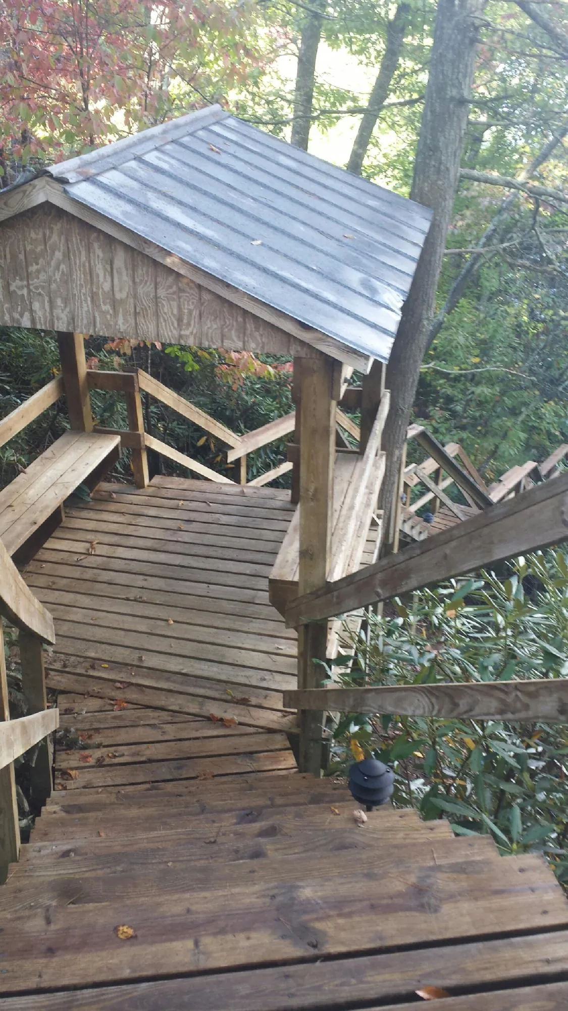 Metal roofed shelter over wooden steps on a wooded walkway — Skylight Repair & Installation work by our crew in Powell
